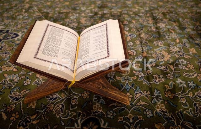 يُفتح كتاب القرآن الكريم على سجادة خضراء في المسجد النبوي في مدينة المدينة المنورة بالمملكة العربية السعودية.