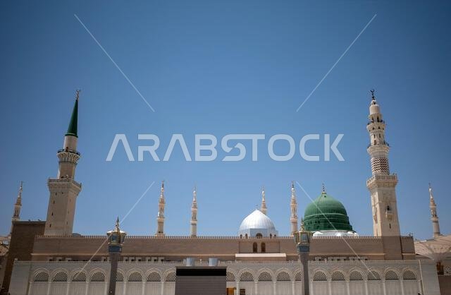 A green dome and minarets in Prophet Mosque in Madinah, also known as Masjid Nabawi, in Saudi Arabia.