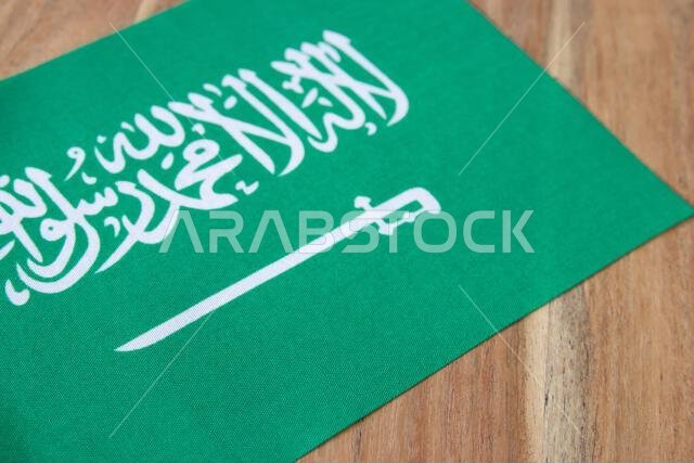 National table flag of Saudi Arabia on the natural wood background.