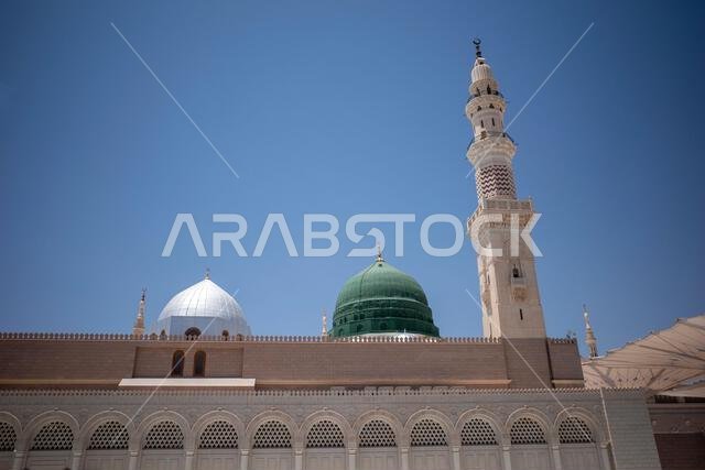 A green dome and minarets in Prophet Mosque in Madinah, also known as Masjid Nabawi, in Saudi Arabia.