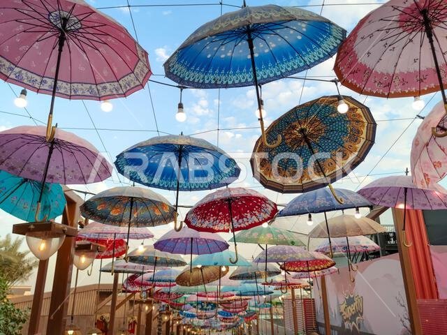 Riyadh,Saudi Arabia-Dec 25, 2025:umbrellas with different patterns hanging upside down from wires over pedestrian area in Boulevard World, Riyadh