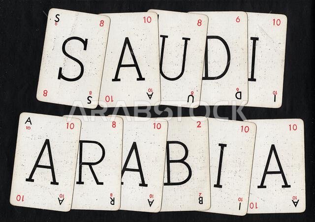 أوراق لعب لعبة الكلمات القديمة التي تُهجّي كلمة "السعودية" معزولة على خلفية سوداء.