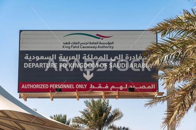 Manama, Bahrain - January 5, 2025: A road sign stands prominently on the King Fahd Causeway, guiding travelers across the vast Arabian Gulf between Ba