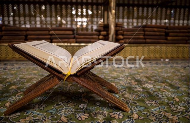 يُفتح كتاب القرآن الكريم على سجادة خضراء في المسجد النبوي في مدينة المدينة المنورة بالمملكة العربية السعودية.