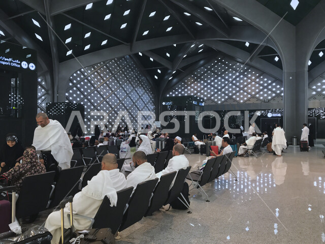 صورة لحجاج بيت الله الحرام يجلسون في غرفة الانتظار  داخل محطة القطار السريع ، محطة قطار سريع لنقل الحجاج من المدينة المنورة لمكة المكرمة ، خدمات نقل آمنة و سريعة للحجاج في موسم الحج