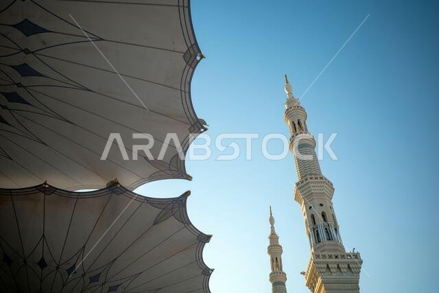The giant automatic Umbrellas and minarets in Prophet Mosque in Madinah, also known as Masjid Nabawi, Saudi Arabia. The giant automatic Umbrellas and minarets in Prophet Mosque in Madinah, also known as Masjid Nabawi, Saudi Arabia.