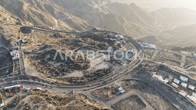 منظر جوي لمدينة الطائف من طائرة بدون طيار، وجبل الهدى في أعلى المدينة، المملكة العربية السعودية، مع إطلالة خلابة على الجبال وطريق الهدى المؤدي إلى مكة المكرمة، جولة سياحية في السعودية