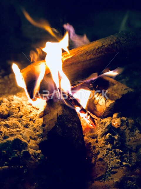 Picture of a burning fire, a firewood flame, burning tree wood, wild trips, winter atmosphere, a road trip in the desert of Saudi Arabia, a popular Arab land session with a flame of wood in the desert of Saudi Arabia, a semi-fire