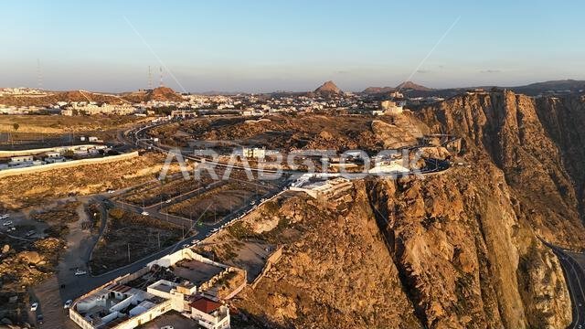منظر جوي لمدينة الطائف من طائرة بدون طيار، وجبل الهدى في أعلى المدينة، المملكة العربية السعودية، مع إطلالة خلابة على الجبال وطريق الهدى المؤدي إلى مكة المكرمة، جولة سياحية في السعودية