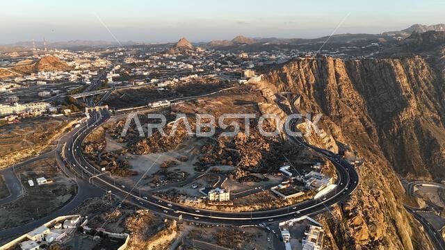 منظر جوي لمدينة الطائف من طائرة بدون طيار، وجبل الهدى في أعلى المدينة، المملكة العربية السعودية، مع إطلالة خلابة على الجبال وطريق الهدى المؤدي إلى مكة المكرمة، جولة سياحية في السعودية