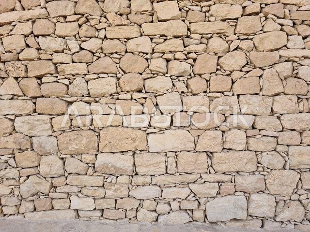صورة مقرّبة لجدار من الحجر الجيري البيج في الرياض، المملكة العربية السعودية