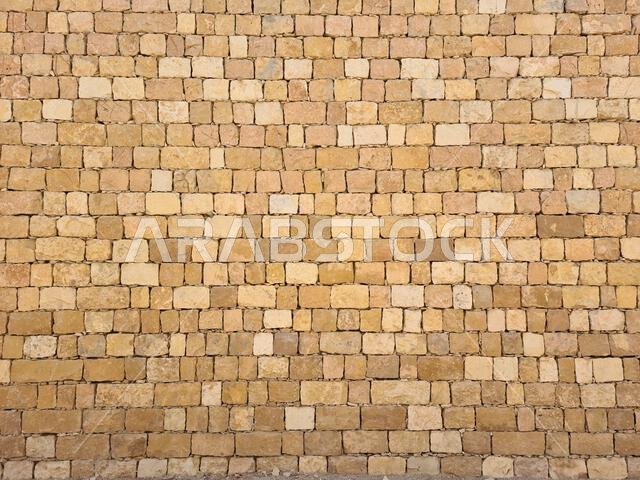 Close-up of a regular yellow limestone brick wall in Riyadh, Saudi Arabia