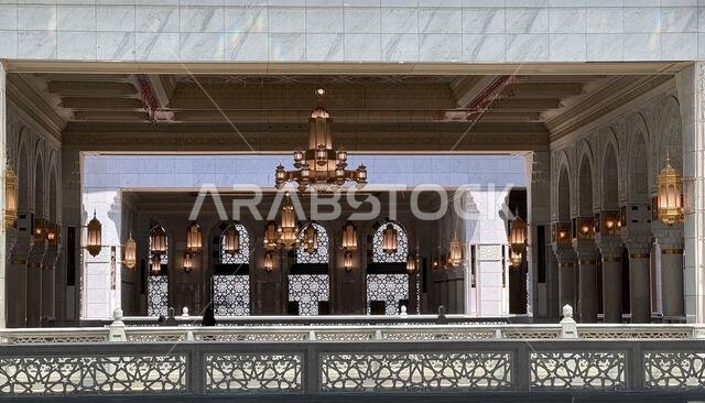 حاج مسلم يؤدي الصلاة داخل المسجد الحرام الكبير في مكة المكرمة، المملكة العربية السعودية. الكعبة المشرفة، والعمارة الإسلامية، والرموز الدينية تشكل لوحة فنية رائعة.