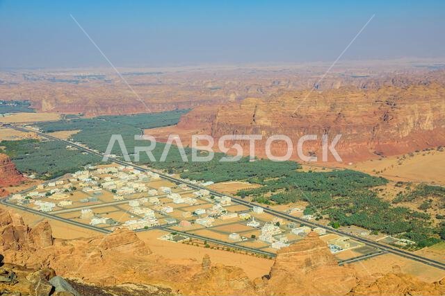 Breathtaking aerial view capturing AlUla Old Town nestled among Saudi Arabia's dramatic desert landscapes, featuring sandstone cliffs and lush palm