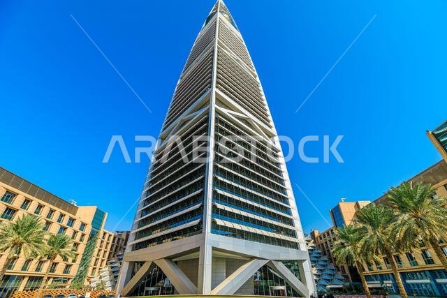 الرياض، المملكة العربية السعودية - 8 يناير 2025: ناطحة سحاب حديثة لمركز المملكة ترتفع شامخة في الرياض، متألقة في سماء زرقاء صافية، تعرض
