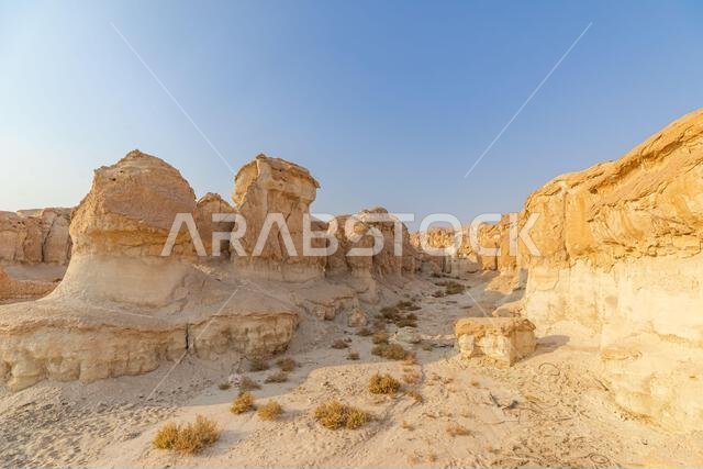 ترتفع التكوينات الرملية المنحوتة بفعل الرياح من أرض الصحراء في جبل القره، الأحساء، المملكة العربية السعودية، لتخلق منظراً طبيعياً ساحراً تحت...