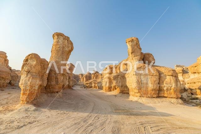 ترتفع التكوينات الرملية المنحوتة بفعل الرياح من أرض الصحراء في جبل القره، الأحساء، المملكة العربية السعودية، لتخلق منظراً طبيعياً ساحراً تحت...