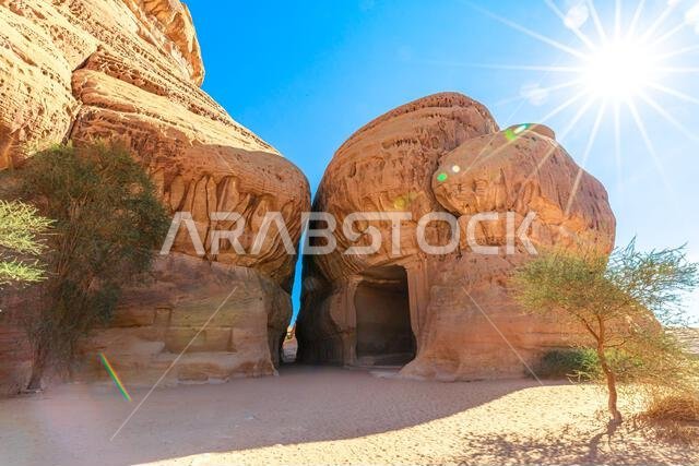 تُضيء أشعة الشمس جبل إثلب والديوان ومقابر السيق المنحوتة في الصخر في الحِجر، العلا، المملكة العربية السعودية، مُبرزةً فن العمارة النبطية القديمة.