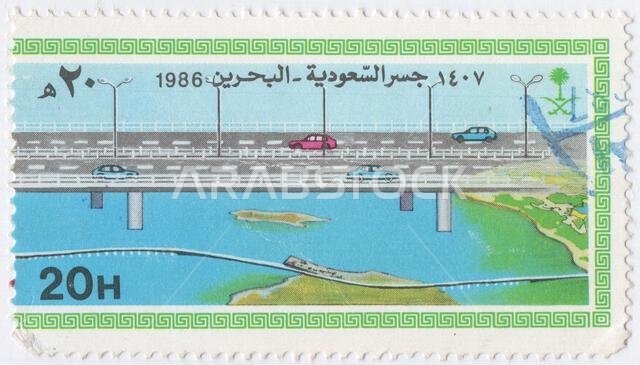 SAUDI ARABIA - 1986 November 26: 20 halalas multicolored postage stamp depicting Highway bridge between Bahrain and Saudi Arabia. Saudi-Bahrain Highway Inauguration. The King Fahd Causeway is a 25 km long series of bridges and causeways connecting Khobar, Saudi Arabia, and Al Jasra, Bahrain. One of the embankments, known as Middle Island has been converted into a sizeable artificial island with customs and immigration facilities, a mosque and gardens and fast food restaurants. Another island tow