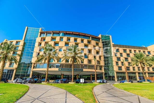 Riyadh , Saudi Arabia - Jannuary 8, 2025: Modern architecture of Mandarin Oriental Hotel in Riyadh, Saudi Arabia, featuring palm trees and parked cars