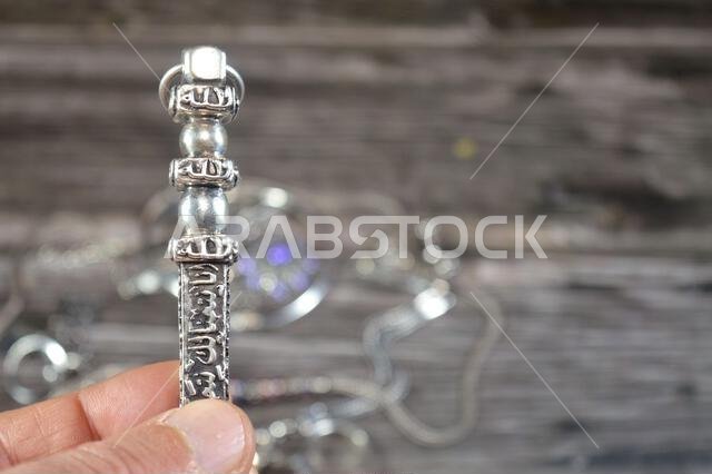Translation of Arabic of Quran verse (Indeed, we have granted you a clear victory) and Allah word on a silver Kaaba Ka'bah key model, silver model of