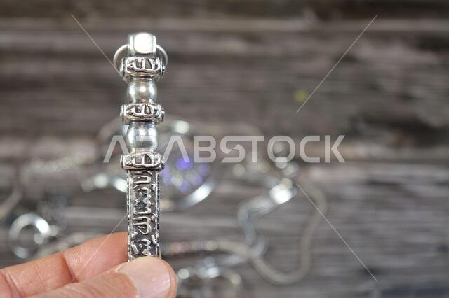 Translation of Arabic of Quran verse (Indeed, we have granted you a clear victory) and Allah word on a silver Kaaba Ka'bah key model, silver model of