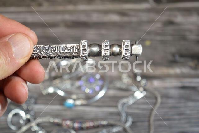 Translation of Arabic of Quran verse (Indeed, we have granted you a clear victory) and Allah word on a silver Kaaba Ka'bah key model, silver model of Translation of Arabic of Quran verse (Indeed, we have granted you a clear victory) and Allah word on a silver Kaaba Ka'bah key model, silver model of
