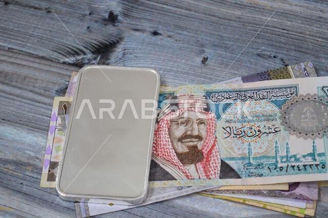 أوراق نقدية سعودية من فئة الريال، وسبائك فضية ثمينة وزنها 250 غرام من الفضة الخالصة. يتأثر سعر الفضة بالمضاربة والعرض والطلب.