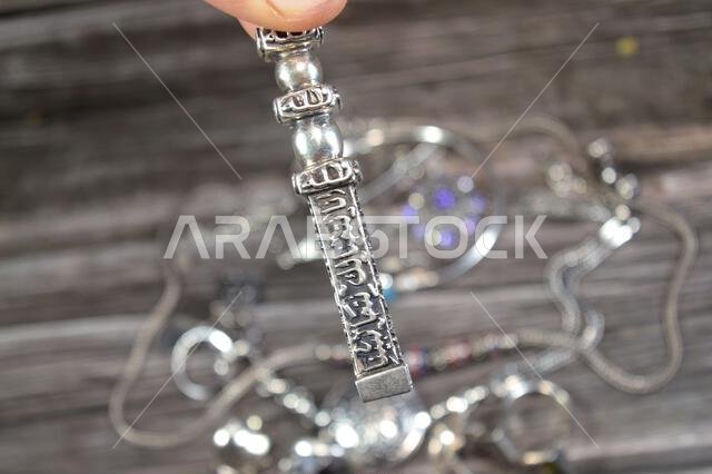 Translation of Arabic of Quran verse (Indeed, we have granted you a clear victory) and Allah word on a silver Kaaba Ka'bah key model, silver model of
