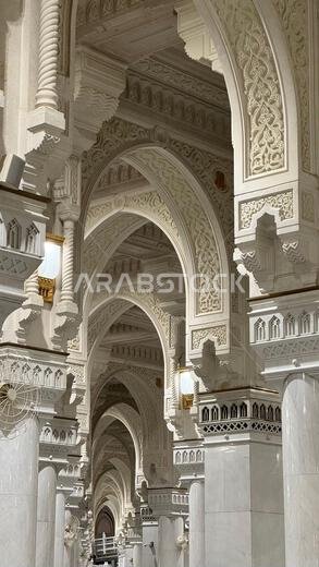 حاج مسلم يؤدي الصلاة داخل المسجد الحرام الكبير في مكة المكرمة، المملكة العربية السعودية. الكعبة المشرفة، والعمارة الإسلامية، والرموز الدينية تشكل لوحة فنية رائعة.