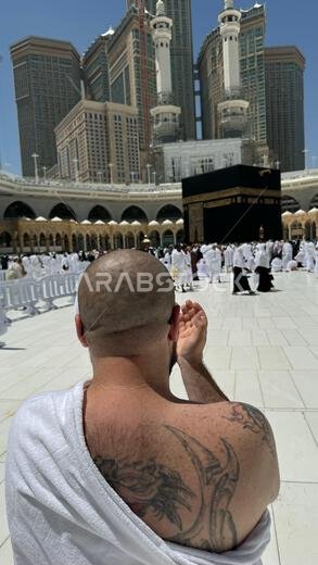 رجل كان من أتباع المذاهب الإجرامية قبل أن يعتنق الإسلام، وله وشم كبير على ظهره وذراعه، يصلي بخشوع في مكة المكرمة وهو ينظر إلى الكعبة المشرفة.