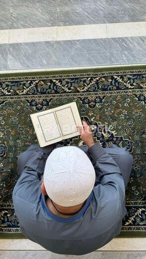 مكة، المملكة العربية السعودية – 2 مايو 2024: شاب حاج ومعتمر يجلس ويقرأ القرآن في المسجد الحرام، المسجد الحرام بمكة المكرمة، المملكة العربية السعودية مكة، المملكة العربية السعودية – 2 مايو 2024: شاب حاج ومعتمر يجلس ويقرأ القرآن في المسجد الحرام، المسجد الحرام بمكة المكرمة، المملكة العربية السعودية