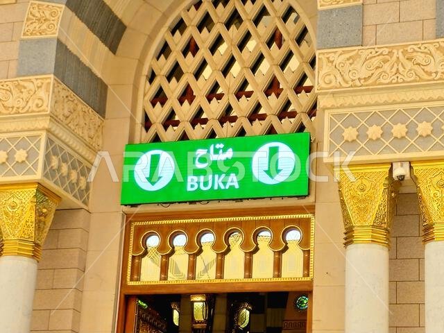 ترجمة النص العربي (متوفرة)، على أحد أبواب المسجد النبوي، وهو موقع رئيسي للحج في المدينة المنورة.