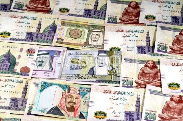 Saudi Arabia riyals SAR cash money bills banknotes and Piles of Egypt money thousands of Pounds currency banknotes bills of 200 EGP LE, Egyptian money