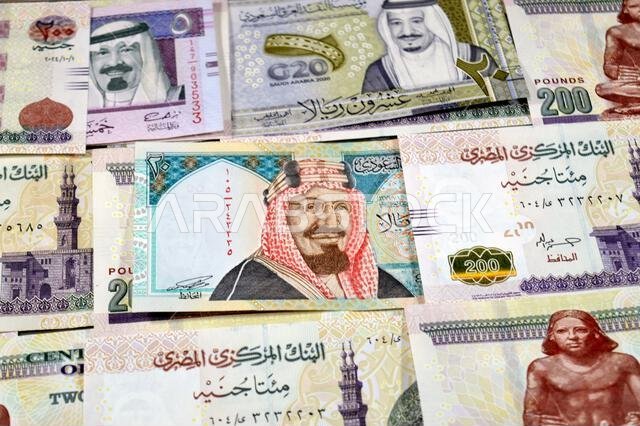 Saudi Arabia riyals SAR cash money bills banknotes and Piles of Egypt money thousands of Pounds currency banknotes bills of 200 EGP LE, Egyptian money