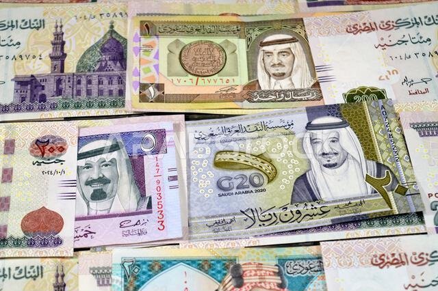 Saudi Arabia riyals SAR cash money bills banknotes and Piles of Egypt money thousands of Pounds currency banknotes bills of 200 EGP LE, Egyptian money