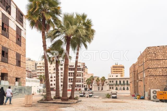 Jeddah, Saudi Arabia - December 21, 2022: A view of a street in the historical Al Balad district with traditional buildings and palm trees. Jeddah, Saudi Arabia - December 21, 2022: A view of a street in the historical Al Balad district with traditional buildings and palm trees.