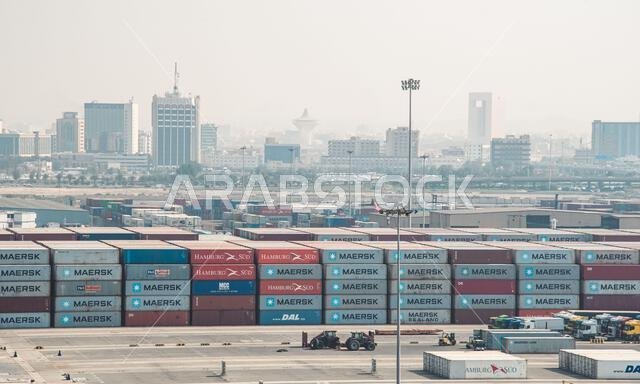 Jeddah, Saudi Arabia - December 21, 2022: Rows of shipping containers dominate the scene at the Jeddah Port, with the city skyline in the distance.