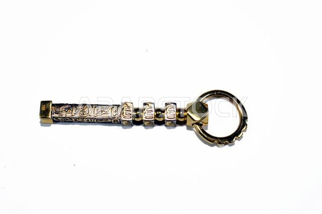 Translation of Arabic of Quran verse (Indeed, we have granted you a clear victory) and Allah word on a golden Kaaba Ka'bah key model, gold model of Ka