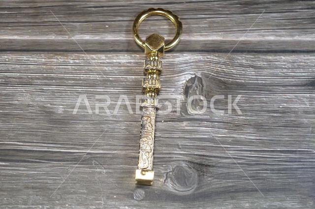 Translation of Arabic of Quran verse (Indeed, we have granted you a clear victory) and Allah word on a golden Kaaba Ka'bah key model, gold model of Ka Translation of Arabic of Quran verse (Indeed, we have granted you a clear victory) and Allah word on a golden Kaaba Ka'bah key model, gold model of Ka