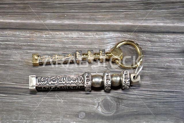ترجمة الآية القرآنية (إنا فتحنا لكم نصراً مبيناً) وكلمة الله على نموذج مفاتيح الكعبة المصنوعة من الذهب والفضة.