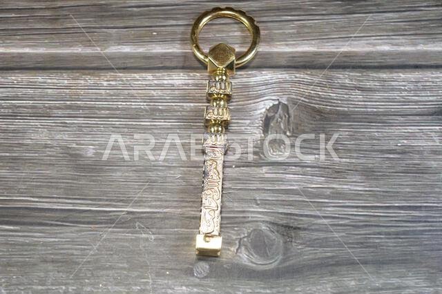 Translation of Arabic of Quran verse (Indeed, we have granted you a clear victory) and Allah word on a golden Kaaba Ka'bah key model, gold model of Ka Translation of Arabic of Quran verse (Indeed, we have granted you a clear victory) and Allah word on a golden Kaaba Ka'bah key model, gold model of Ka