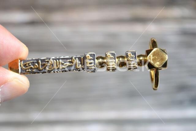 Translation of Arabic of Quran verse (Indeed, we have granted you a clear victory) and Allah word on a golden Kaaba Ka'bah key model, gold model of Ka Translation of Arabic of Quran verse (Indeed, we have granted you a clear victory) and Allah word on a golden Kaaba Ka'bah key model, gold model of Ka