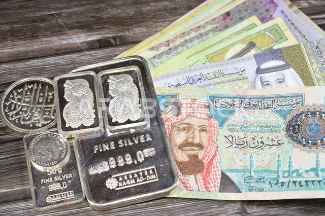 Cairo, Egypt, May 16 2025: Saudi Arabia riyals money banknotes and Nagm Ad-Din pure fine silver bars, silver investment, exchange price rate, inflatio
