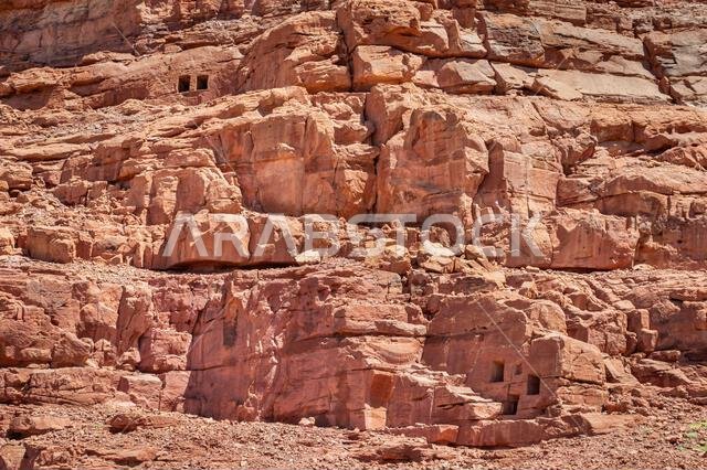 View of rock mountains with carved tombs at Dadan Alula in a sunny day.