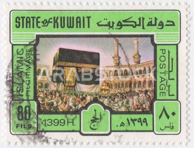 الكويت - ٢٩ أكتوبر ١٩٧٩: طابع بريدي متعدد الألوان بقيمة ٨٠ فلسًا، يصور الحجاج عند الكعبة المشرفة في المسجد الحرام بمكة المكرمة. عام الهجرة (سنة الحج). الكعبة المشرفة هي بناء حجري يقع في قلب المسجد الحرام بمكة المكرمة، أهم مساجد الإسلام وأقدس مواقعه. يعتبرها المسلمون بيت الله الحرام، وهي التي تحدد القبلة للمسلمين في جميع أنحاء العالم. ويحيط الحجاج بالكعبة والمطعم كل يوم من أيام السنة الهجرية.
