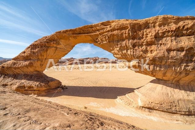 تُحيط المناظر الطبيعية الصحراوية البانورامية قرب العلا بقوس قوس قزح المذهل، وهو تكوين صخري رملي رائع، يُعدّ من عجائب التكوينات الجيولوجية في المملكة العربية السعودية. تُحيط المناظر الطبيعية الصحراوية البانورامية قرب العلا بقوس قوس قزح المذهل، وهو تكوين صخري رملي رائع، يُعدّ من عجائب التكوينات الجيولوجية في المملكة العربية السعودية.
