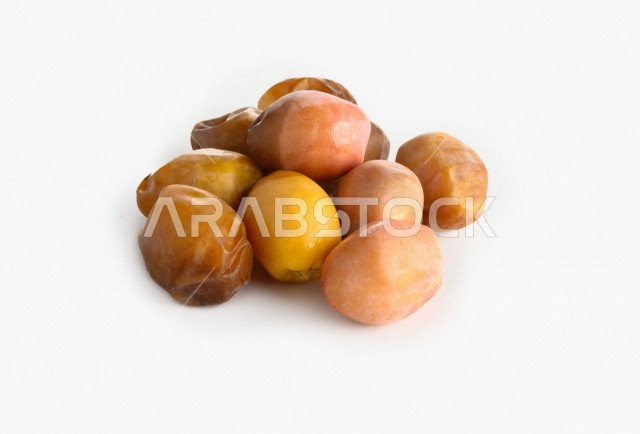 بلح اصفر من نخيل المملكه العربيه السعوديه, حصاد النخيل في مزارع المملكه, تمر منيفي, رطب ملكي فاخر بخلفية بيضاء