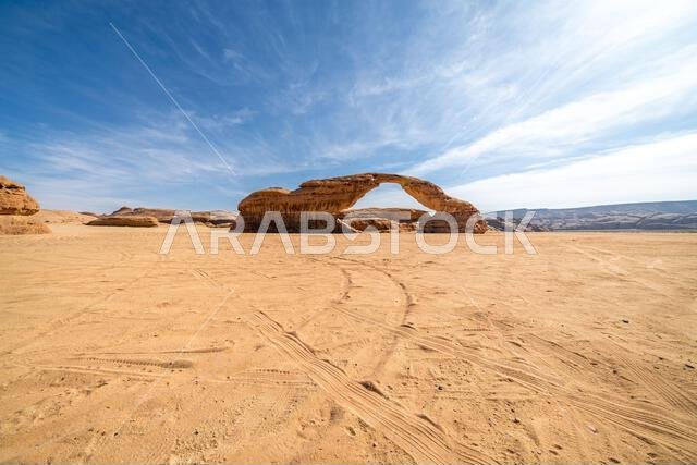 تُحيط المناظر الطبيعية الصحراوية البانورامية قرب العلا بقوس قوس قزح المذهل، وهو تكوين صخري رملي رائع، يُعدّ من عجائب التكوينات الجيولوجية في المملكة العربية السعودية. تُحيط المناظر الطبيعية الصحراوية البانورامية قرب العلا بقوس قوس قزح المذهل، وهو تكوين صخري رملي رائع، يُعدّ من عجائب التكوينات الجيولوجية في المملكة العربية السعودية.