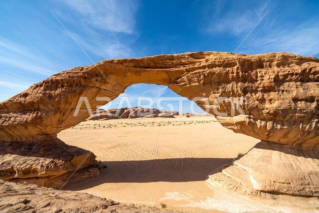 تُحيط المناظر الطبيعية الصحراوية البانورامية قرب العلا بقوس قوس قزح المذهل، وهو تكوين صخري رملي رائع، يُعدّ من عجائب التكوينات الجيولوجية في المملكة العربية السعودية. تُحيط المناظر الطبيعية الصحراوية البانورامية قرب العلا بقوس قوس قزح المذهل، وهو تكوين صخري رملي رائع، يُعدّ من عجائب التكوينات الجيولوجية في المملكة العربية السعودية.